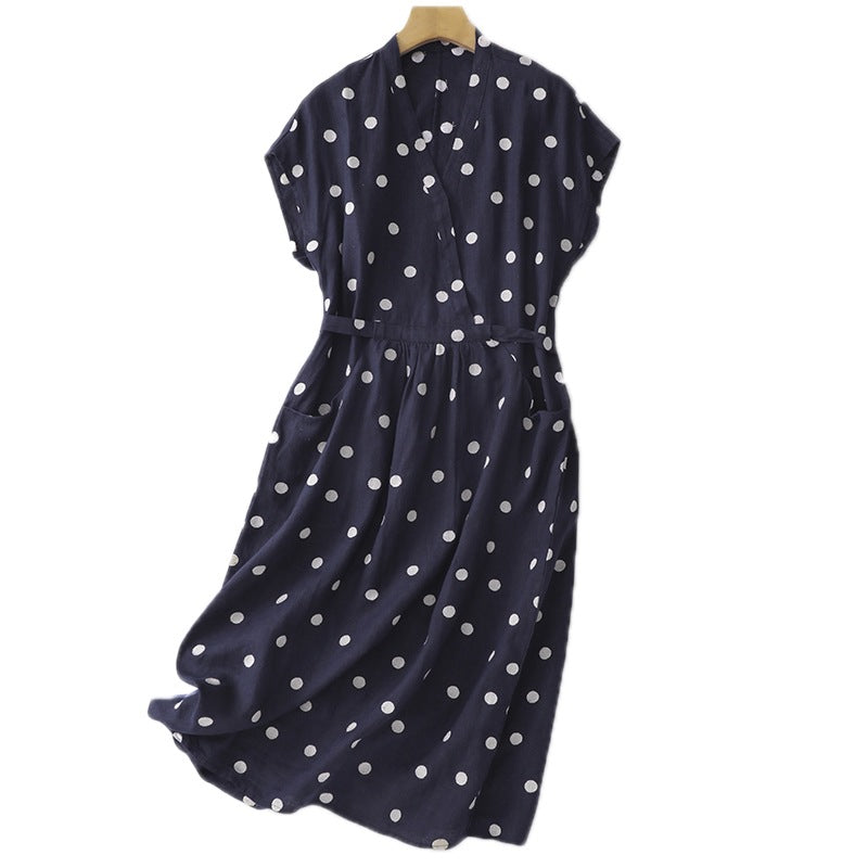 Back view of a navy blue polka dot midi dress on a hanger showing the A-line shape