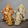 Gold-tone and sandstone finish Ganesha resin statues sitting on a wooden surface