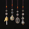 Four hanging keychains showing different alloy charms including a prayer wheel and vajra on brown cords