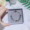 Gold-tone bracelet with green phantom crystal beads in a grey gift box