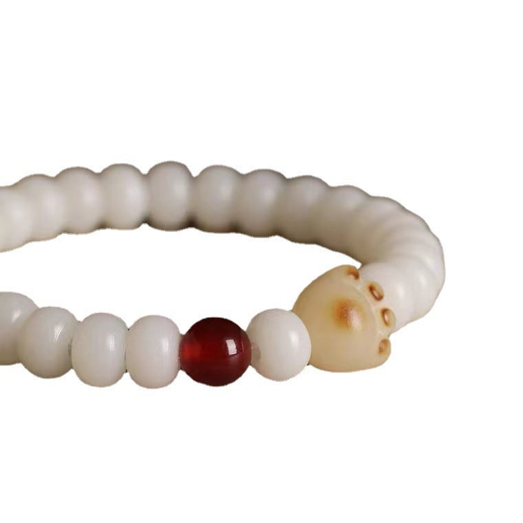 White bodhi seed bracelet with a carved cat paw charm