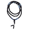 A coiled strand of black obsidian and blue kyanite beads resting on a wooden jewelry tray.