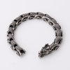 Close-up view of a silver-tone titanium steel bracelet with a dragon head clasp