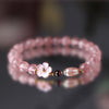 Pink Strawberry Quartz beaded bracelet with a white flower charm