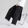 Man wearing loose black cotton linen pants with side pockets