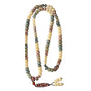 Close up view of a multi-colored bodhi seed mala necklace with a red agate dzi pendant
