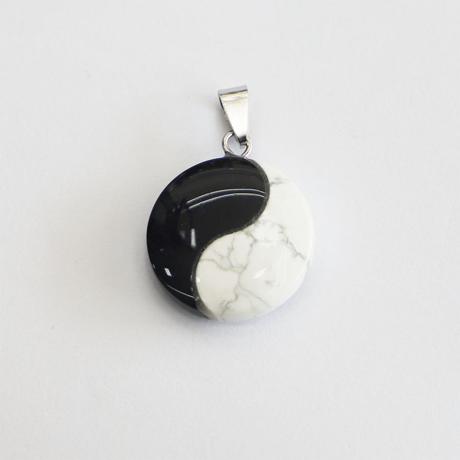 Round white turquoise pendant with black Yin Yang symbol on silver-tone bail