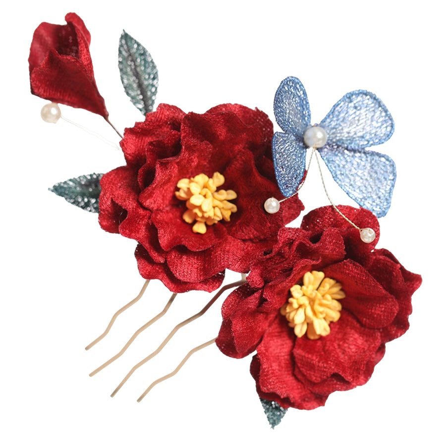 Close up view of a red floral hair comb with a blue butterfly and pearl details
