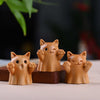 Three small carved wooden cat figurines sitting on a table