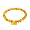 Gold tiger eye beaded bracelet with a gold-tone lotus flower and seed pod charm on a white background