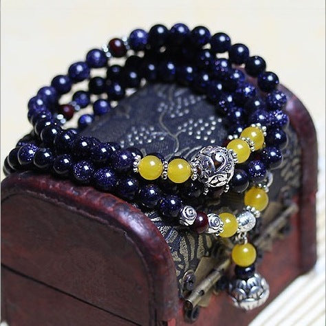 Close-up of blue sandstone bead bracelet wrapped around a wooden box