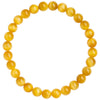 A wrist wearing a simple yellow tiger eye bead bracelet against a neutral background