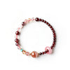 Woman wearing a pink and red beaded bracelet with a sliding ring charm