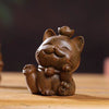 Two small carved wooden cats sitting side by side on a table