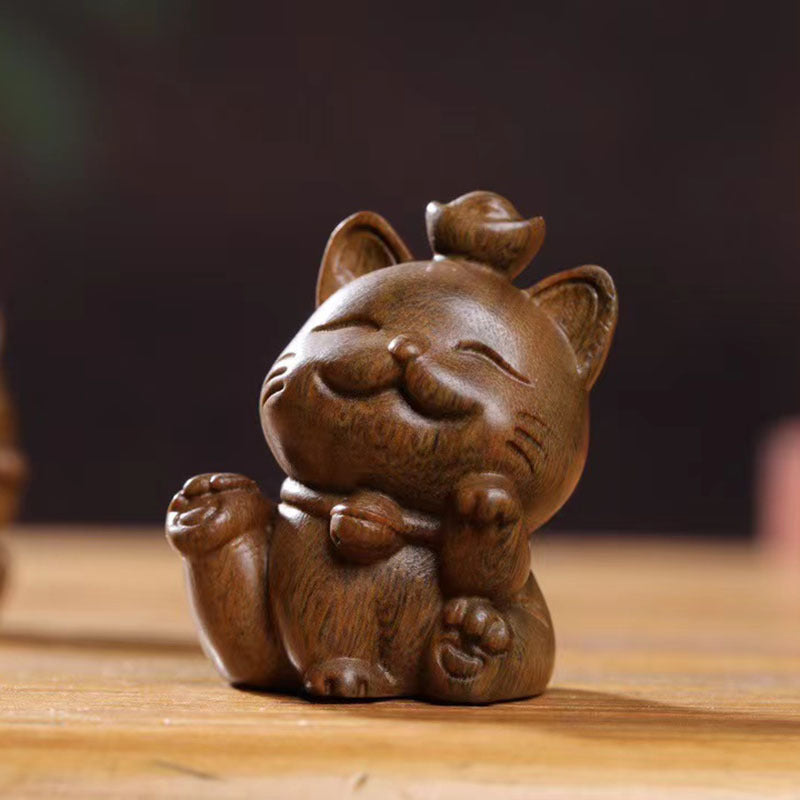 Two small carved wooden cats sitting side by side on a table