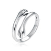 Close up of a silver ring with two hands embracing each other