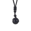 Close-up of a black natural stone bead pendant on a black cord necklace
