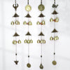 Four variations of a gold-tone alloy wind chime with bells and charms hanging vertically
