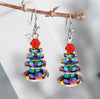 Pair of Christmas tree earrings hanging on a branch