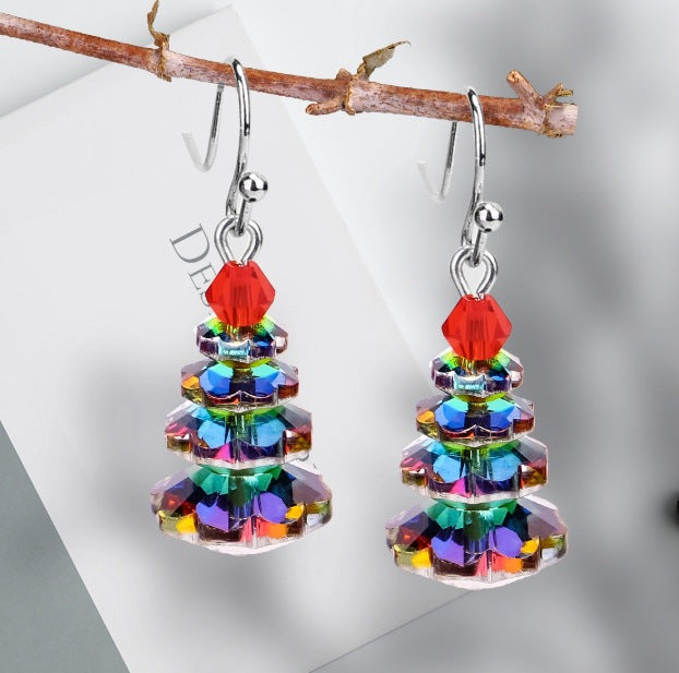 Pair of Christmas tree earrings hanging on a branch