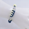 Close up of a blue and cream woven knot bracelet on a wrist