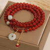 Triple wrap red agate bracelet with jade peace buckle on a box