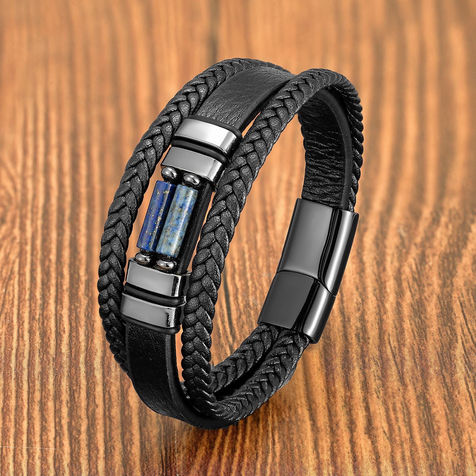 Black braided leather bracelet with a rectangular blue stone inlay and magnetic clasp on a wooden surface