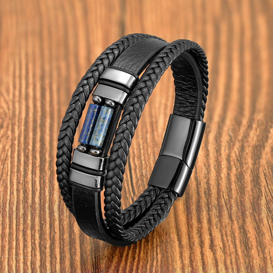Close up of black braided leather bracelet with blue stone inlay on wood surface