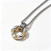 Close-up of a silver-tone twisted ring pendant with gold coin details on a chain