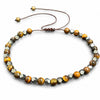 Close up of a wrist wearing a brown and black beaded bracelet with an adjustable cord
