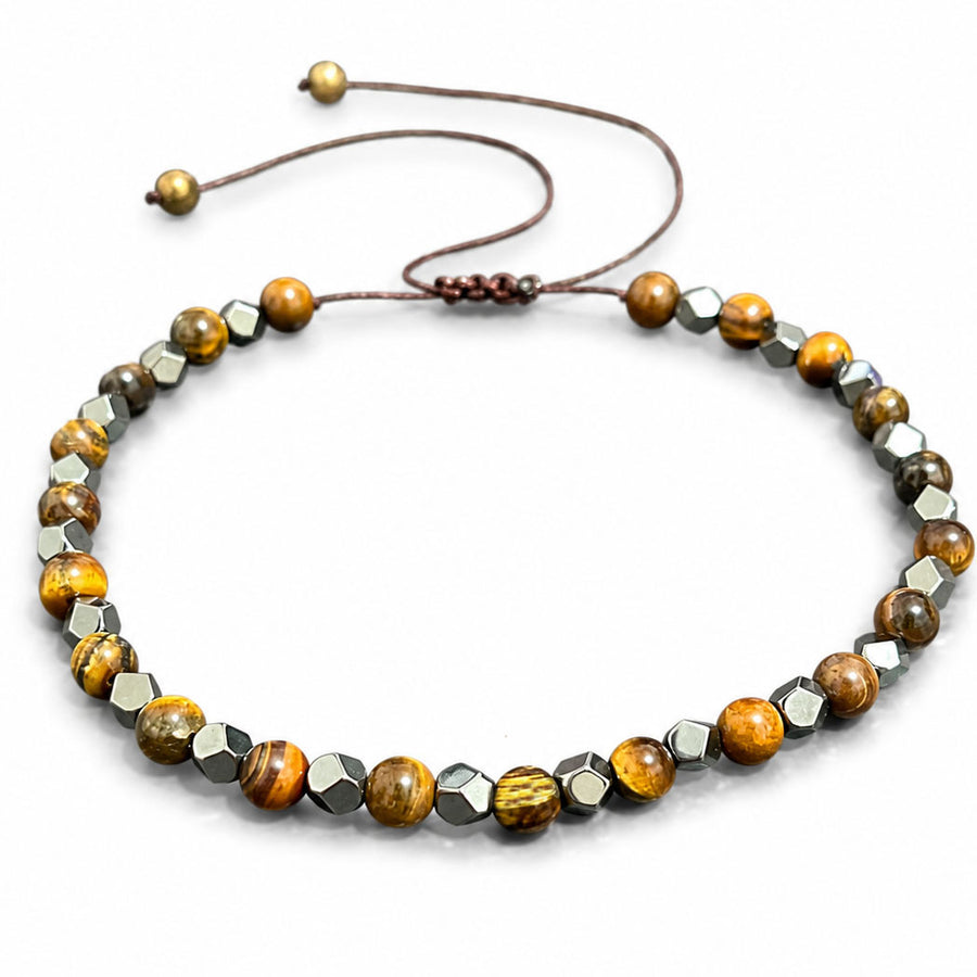 Close up of a wrist wearing a brown and black beaded bracelet with an adjustable cord