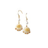 Close up of white bodhi seed cat paw earring on ear