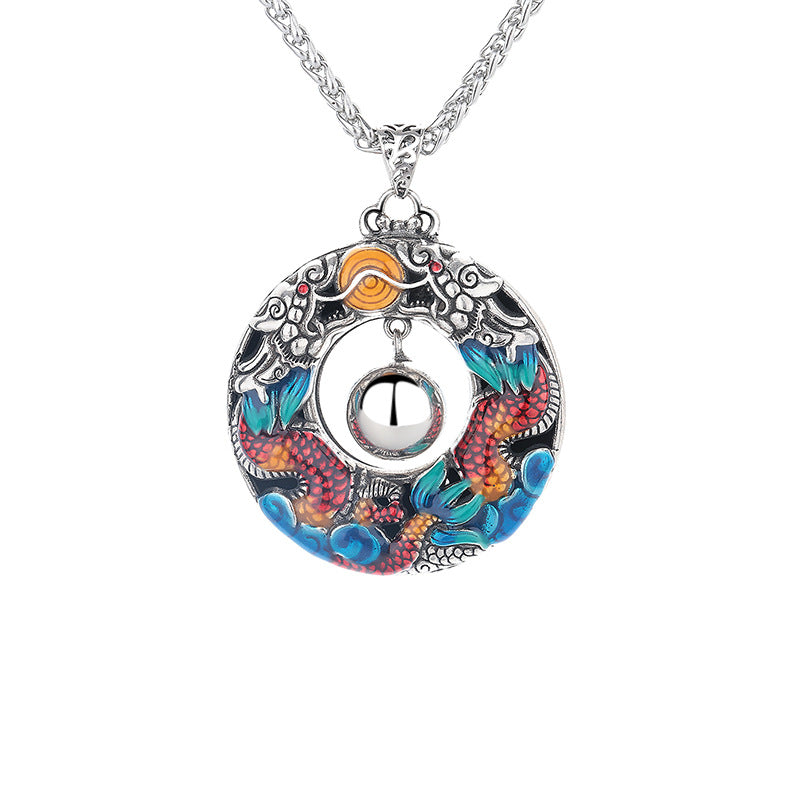 Round copper pendant with colorful enamel double dragons playing with a bead on a silver tone chain