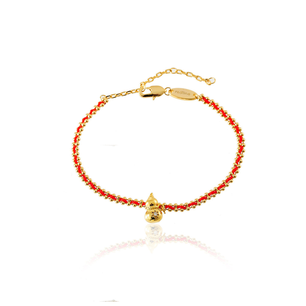 Gold tone gourd charm on a red and gold braided bracelet