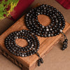 Coiled silver sheen obsidian mala beads on a wooden display block