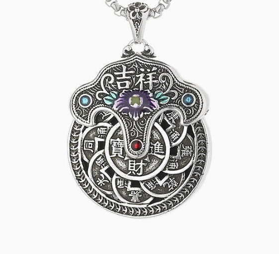 Close up of a silver tone copper pendant with a purple flower and coin design on a box chain