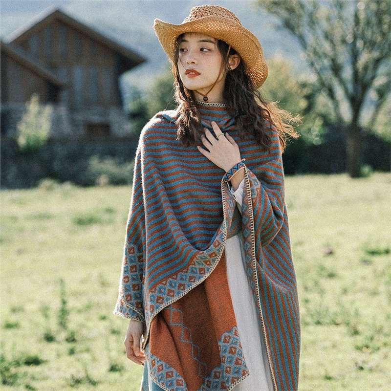 Woman wearing a striped orange and grey Tibetan shawl in a field