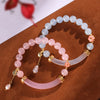 Close up of pink and blue chalcedony half bangle bracelets with pearl charms on brown surface
