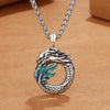 Close up of a copper dragon pendant necklace with blue enamel wings on a silver tone chain.