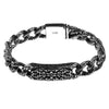 Close up of a silver tone copper bracelet with intricate engraved patterns on a wooden surface