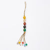 A hand holding a handmade agate bead tassel with a colorful braided cord.