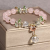Close-up of a beaded crystal bracelet with gold-tone spacers and a hanging faceted charm
