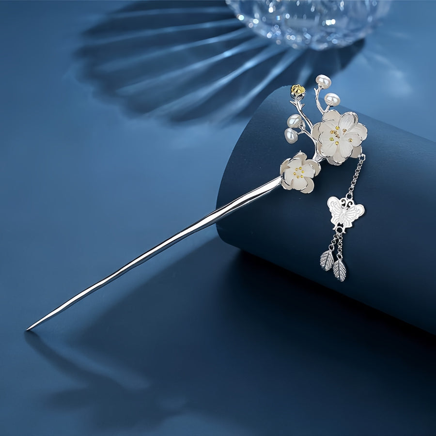 Silver tone hair stick with white flowers and butterfly charm on blue background