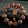 Close up of dark brown wooden bracelet with carved Chinese characters and a square tag