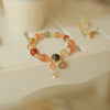 Close-up of a multi-colored crystal bracelet with gold charms on a white surface