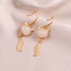 Gold-tone copper earrings shaped like a fox head with a white jade center