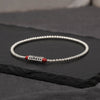 Silver tone beaded chain with red cinnabar beads and a mantra cylinder
