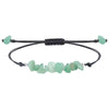 A close up of a green aventurine chip bracelet on a black cord with an adjustable sliding knot.