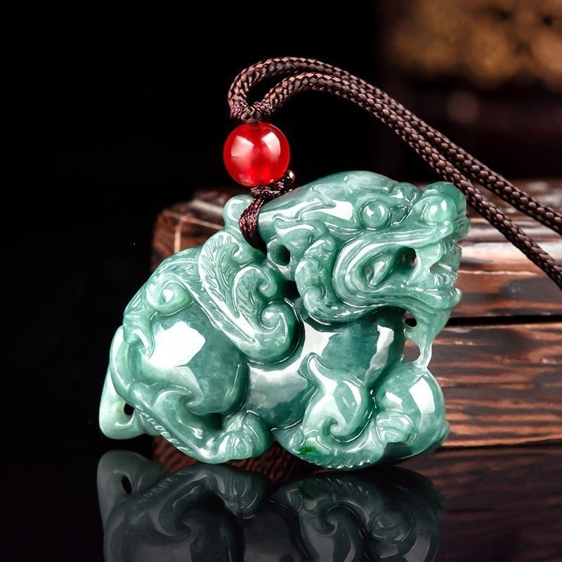 Close-up of a carved green jade Pixiu pendant on a brown cord