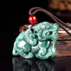 Close-up of a carved green jade Pixiu pendant on a brown cord